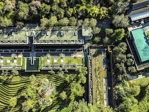 An aerial view of a hotel with a central courtyard, multiple buildings, and a swimming pool.