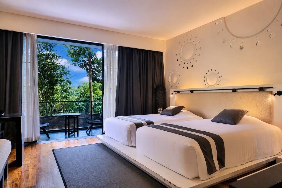Ein Doppelbett mit Kopfteil, ein kleiner Tisch und ein Stuhl in einem Zimmer mit Balkon.