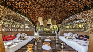 Un amplio salón al aire libre con techos altos de madera y delicados diseños de celosía.