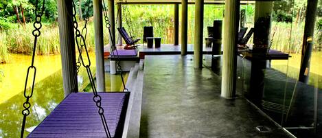 Un espacio interior moderno con fuente de agua, zonas de estar y ventanas amplias.