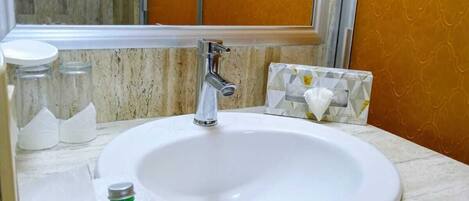 A bathroom with a white sink, a mirror, and a towel rack.