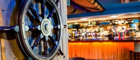 A bar with a wooden wheel and a bar counter.
