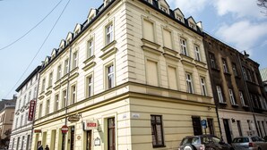 Um edifício com vários andares, com placa indicando um albergue e um prédio de apartamentos.