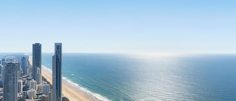 Un paysage urbain côtier avec de hauts immeubles, une plage et l’océan.