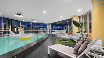 Relax by the pool with a clear view of the night sky through large windows.
