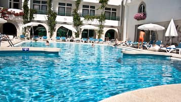 Una piscina al aire libre de temporada, sombrillas