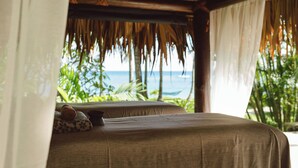 Una habitación con cama, almohada y vista al océano.
