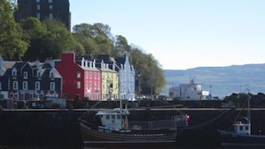 A harbor with boats, colorful buildings, and a clear view of the water. - Tobermory Youth Hostel (Isle of Mull)