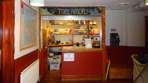 A reception desk with a sign reading "TOBERMORY" and a map on the wall. - Tobermory Youth Hostel (Isle of Mull)