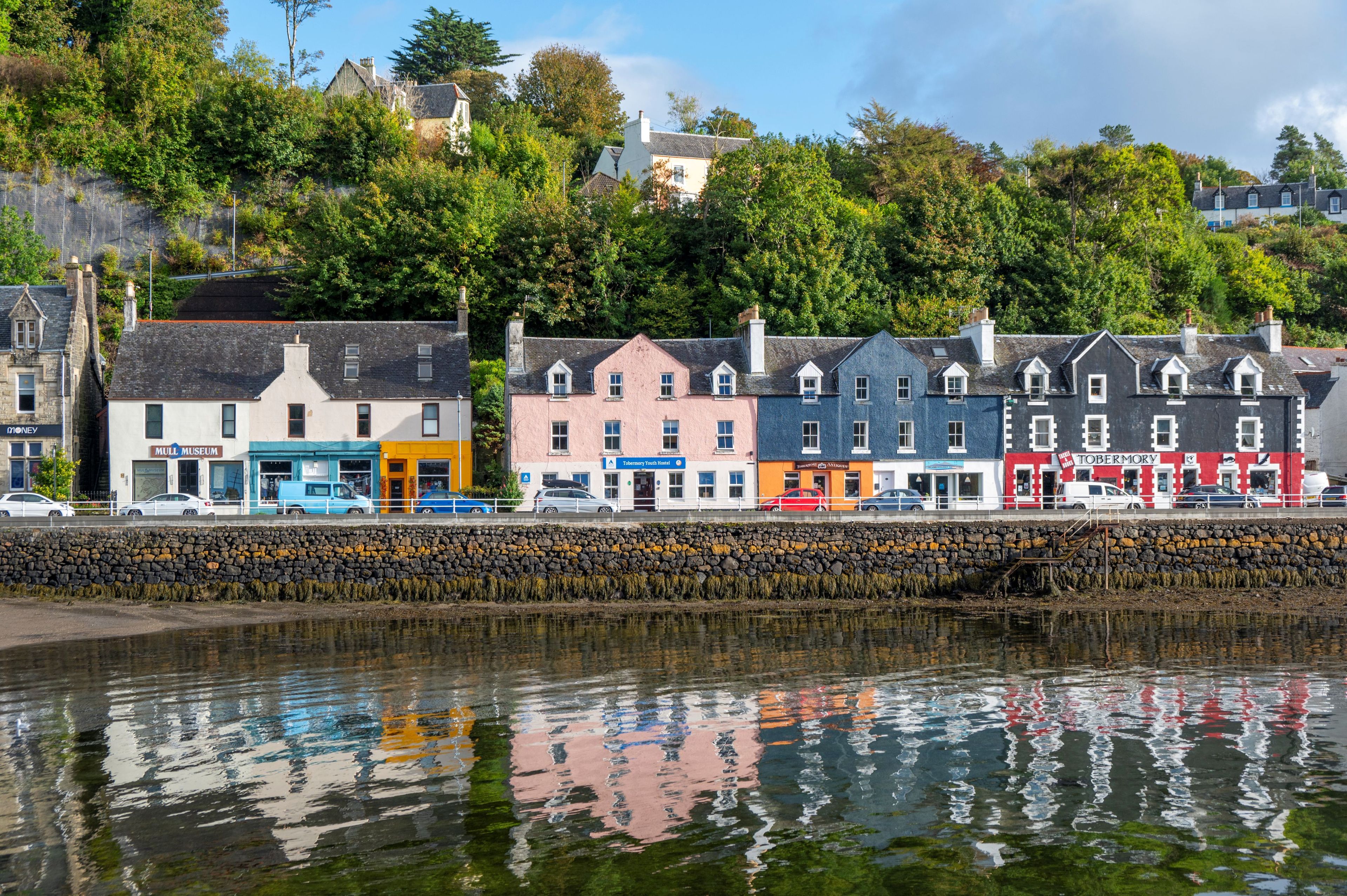 A waterfront view with buildings, including a museum and a youth hostel, along a stone wall.