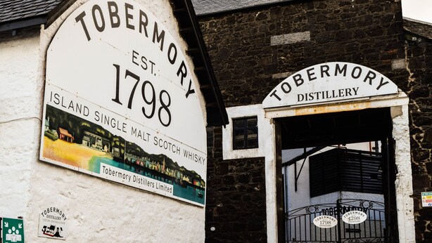 A sign for Tobermory Distillery, established in 1798, with a view of the entrance and a small window above the door. - Tobermory Youth Hostel (Isle of Mull)