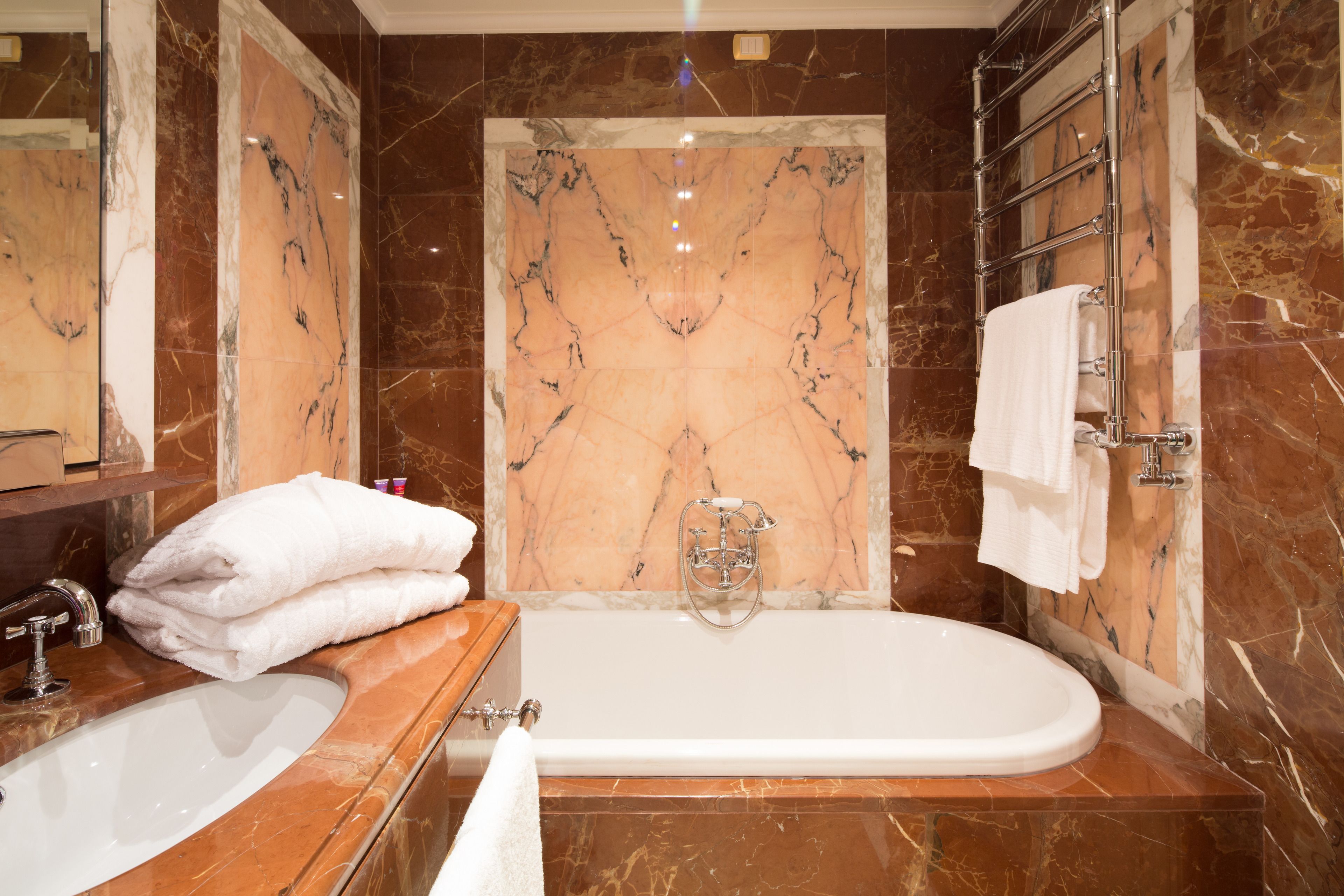 A bathroom with a marble sink, a bathtub, and a shower.