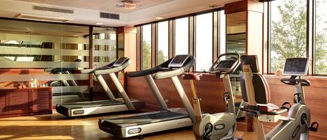 A gym with treadmills, an elliptical, and a stationary bike.