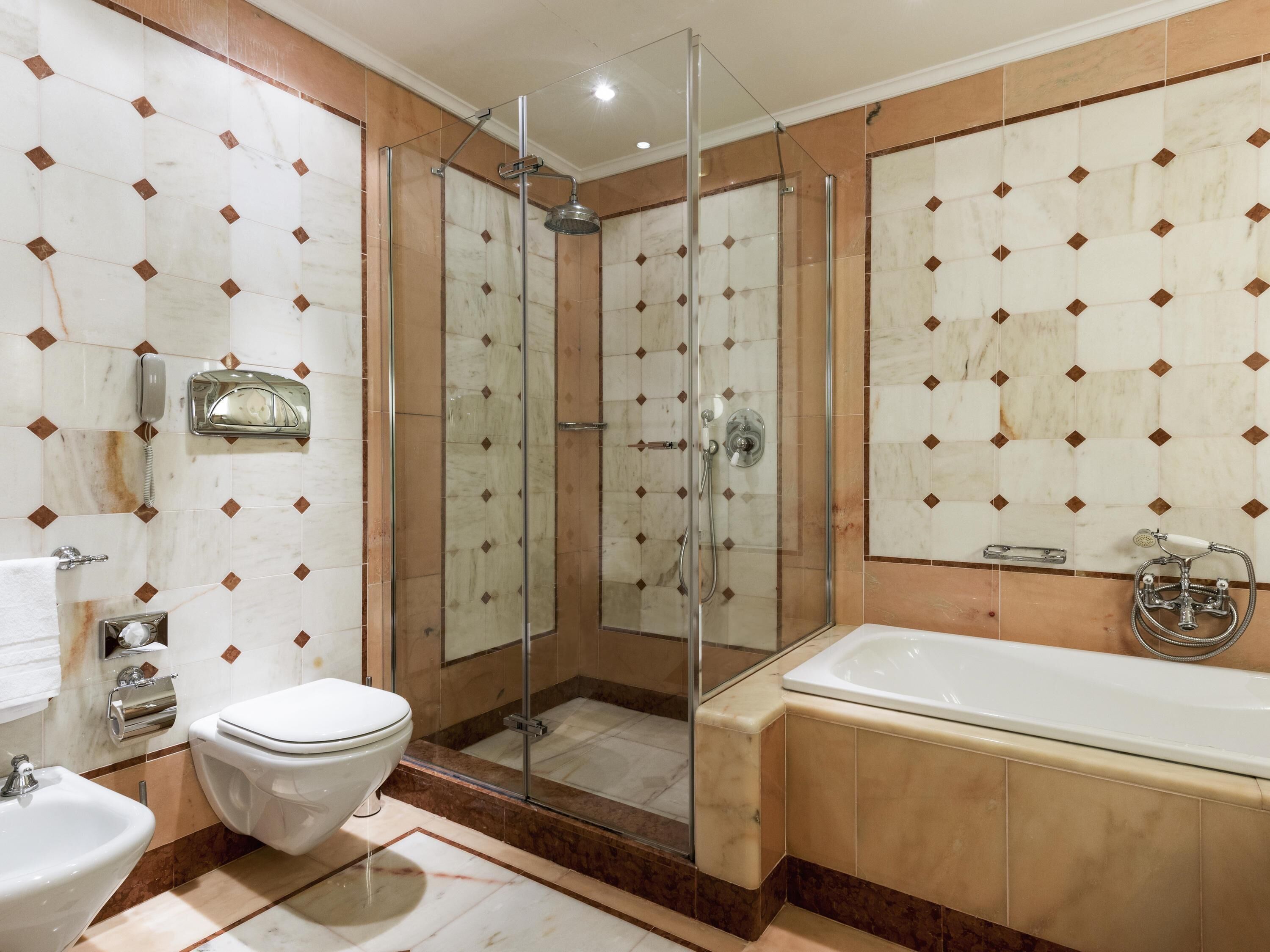 Une salle de bain moderne avec une douche à parois de verre, une baignoire, des toilettes et un lavabo.