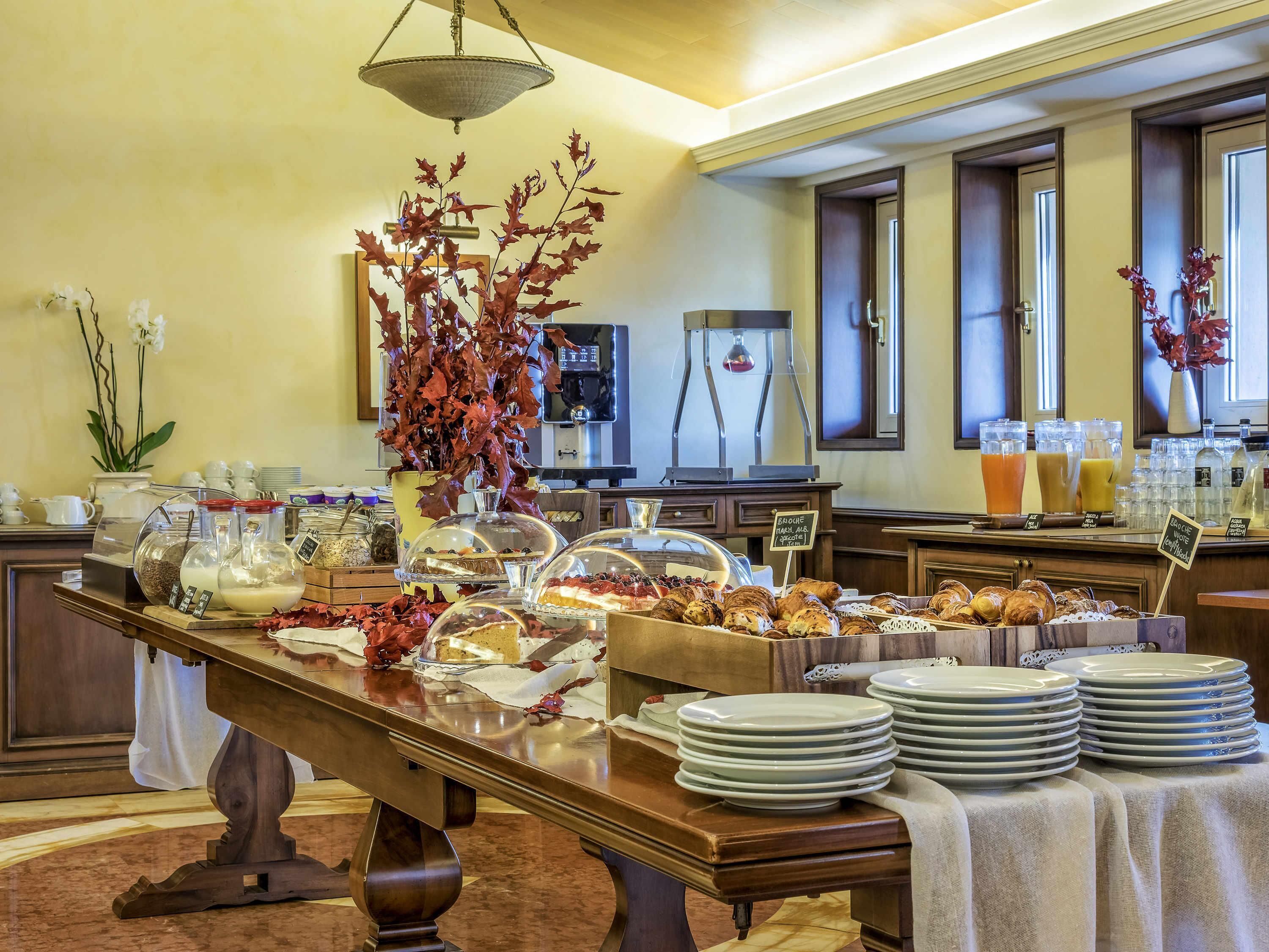 Ein reichhaltiges Buffet mit verschiedenen Speisen, einer Kaffeemaschine und einer dekorativen Pflanzengestaltung.
