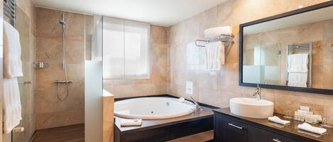 A modern bathroom with a walk-in shower, a freestanding bathtub, a vanity with a sink, and a large mirror.