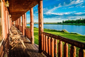 A wooden deck with benches overlooking a river. - Anglers Lodge (Island Park)