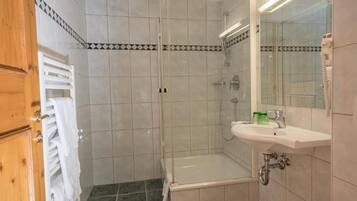 Un baño con ducha, bañera, lavabo e inodoro.