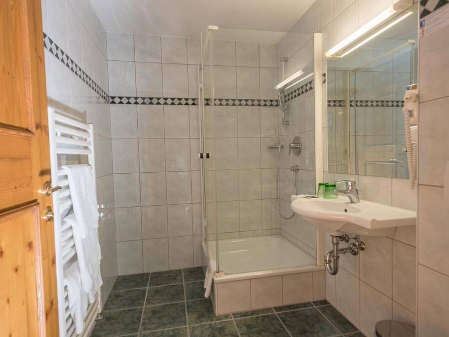 Un baño con ducha, bañera, lavabo e inodoro.