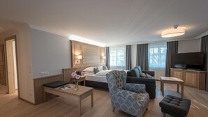 Une chambre d’hôtel moderne équipée d’un lit, d’un canapé, d’une télévision et d’un coin repas.