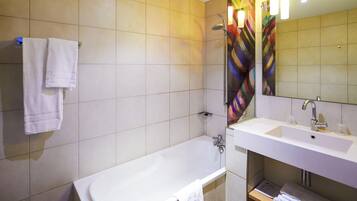 Een moderne badkamer met een bad, een wastafel en een spiegel.