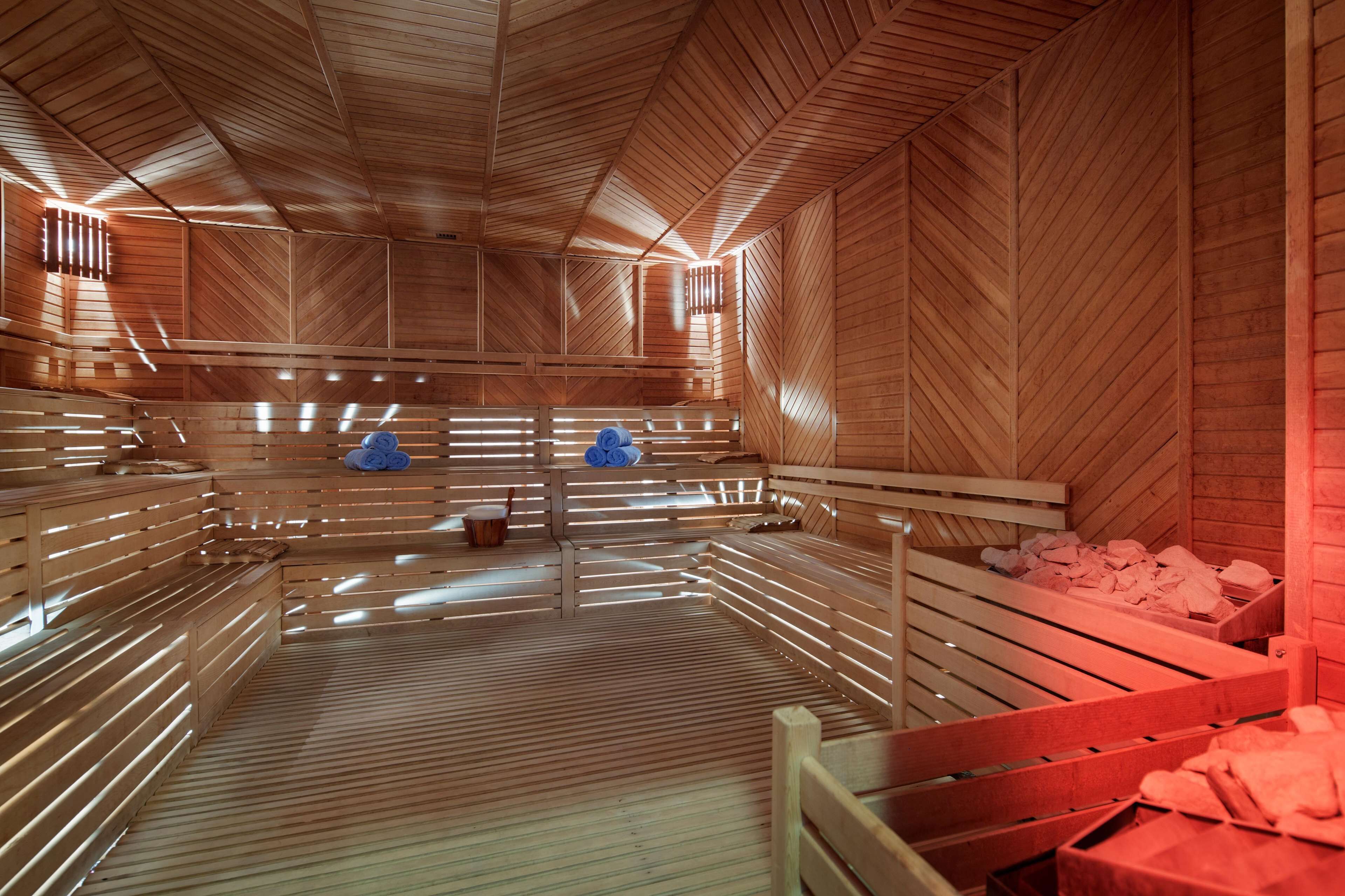 Eine Sauna mit Holzbänken, einer Mittelstütze und einem Holzboden.