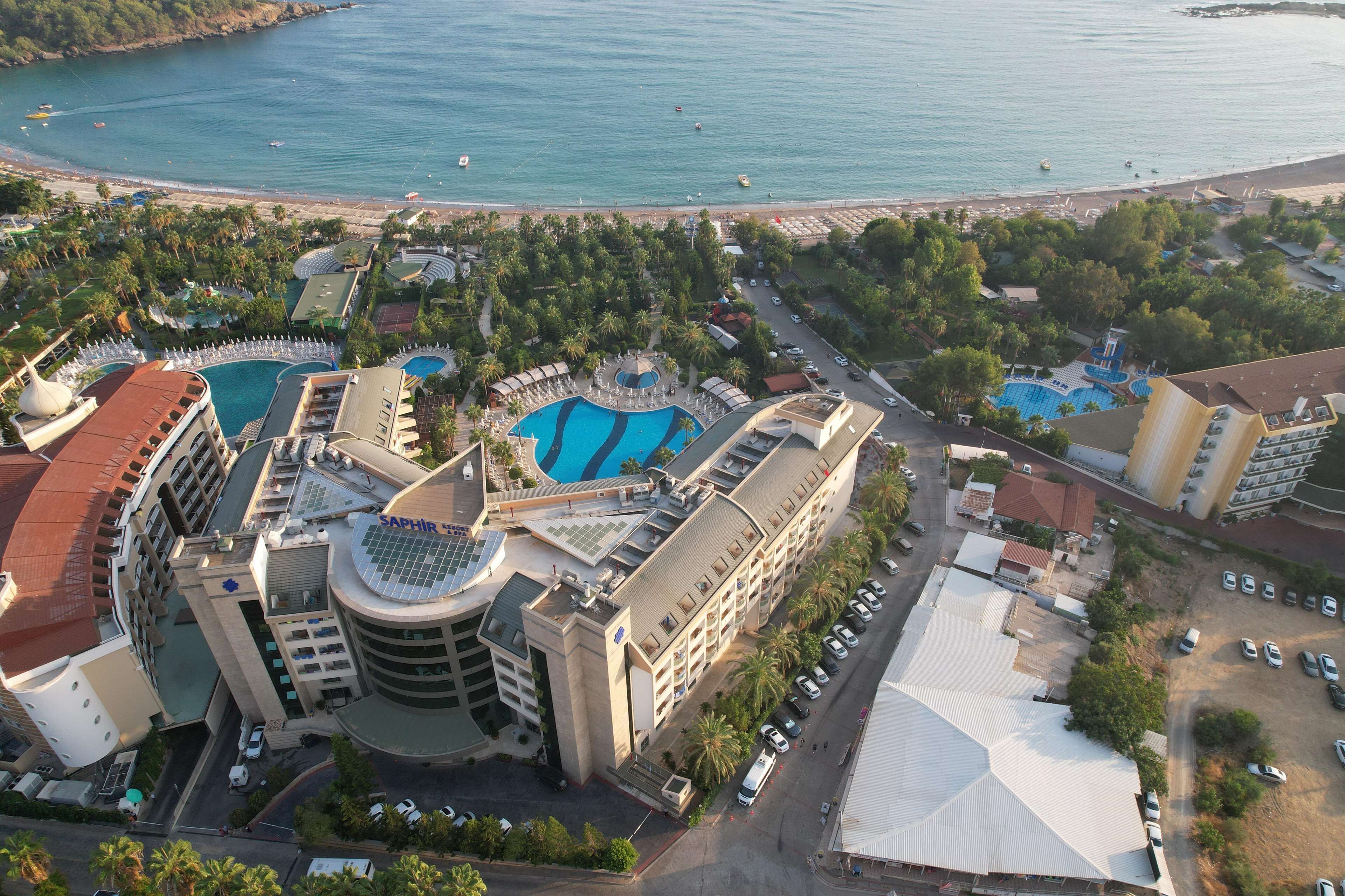 A resort with multiple swimming pools, a beach, and a parking area.