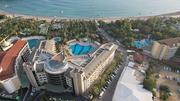 A resort with multiple swimming pools, a beach, and a parking area.