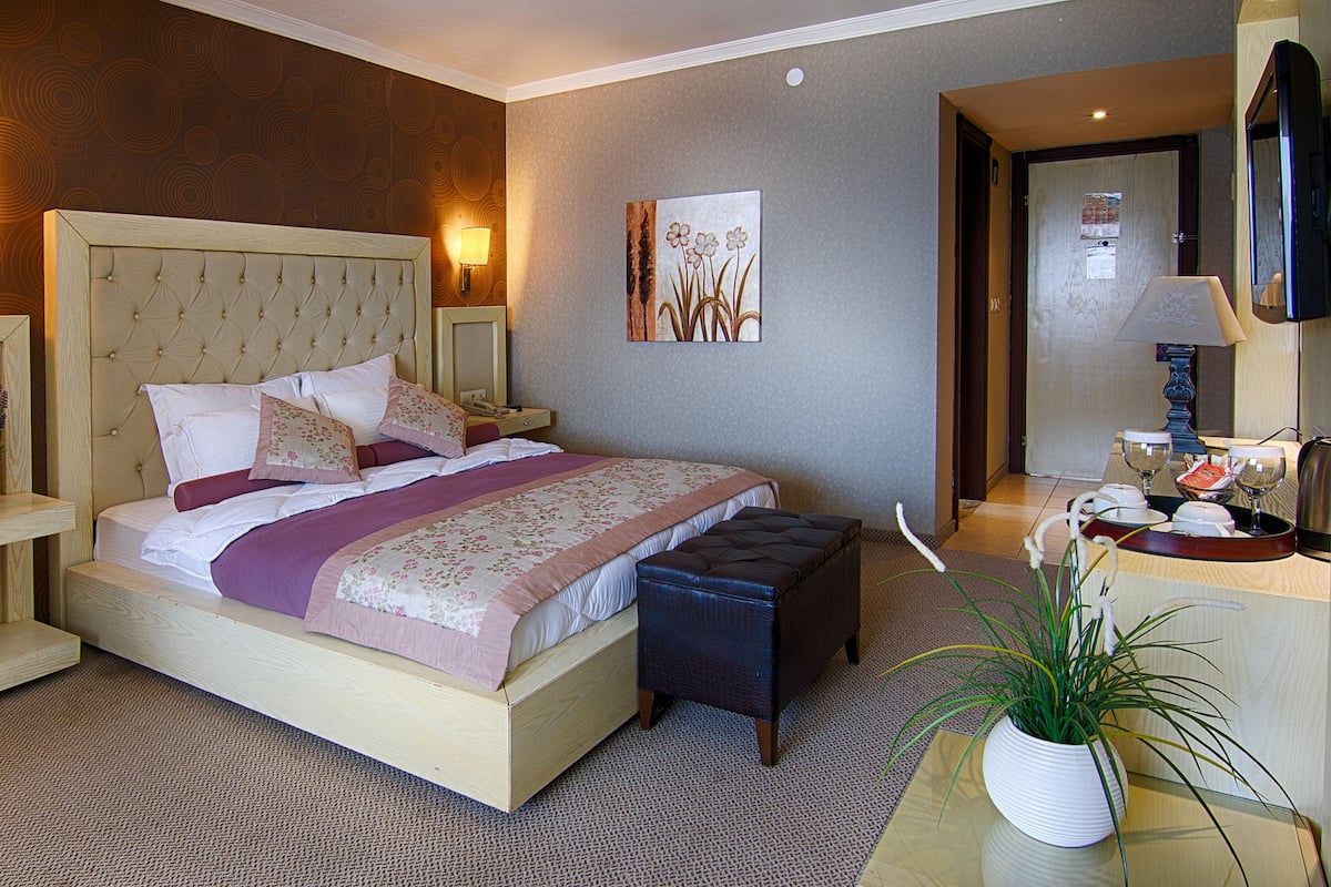 Deluxe kamer | Luxe beddengoed, een minibar, een kluis op de kamer, een bureau
