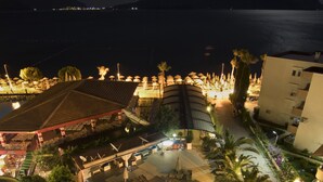 Un resort con piscina, sillas de descanso y vista al mar.