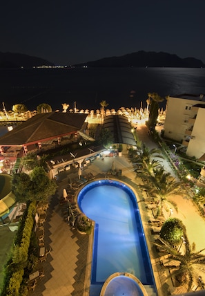 Een buitenzwembad, ligstoelen bij het zwembad