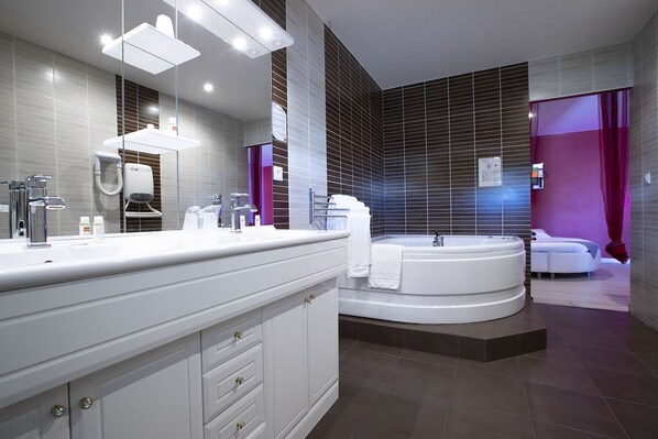 A modern bathroom with a large vanity, a freestanding bathtub, and a separate shower area. - In Jungle hôtel (Beauvallon)
