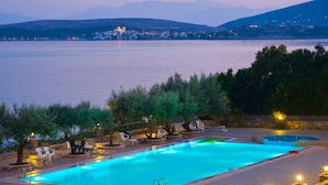 A swimming pool with a view of a body of water and distant mountains. - Europa Beach Hotel (Delphi)