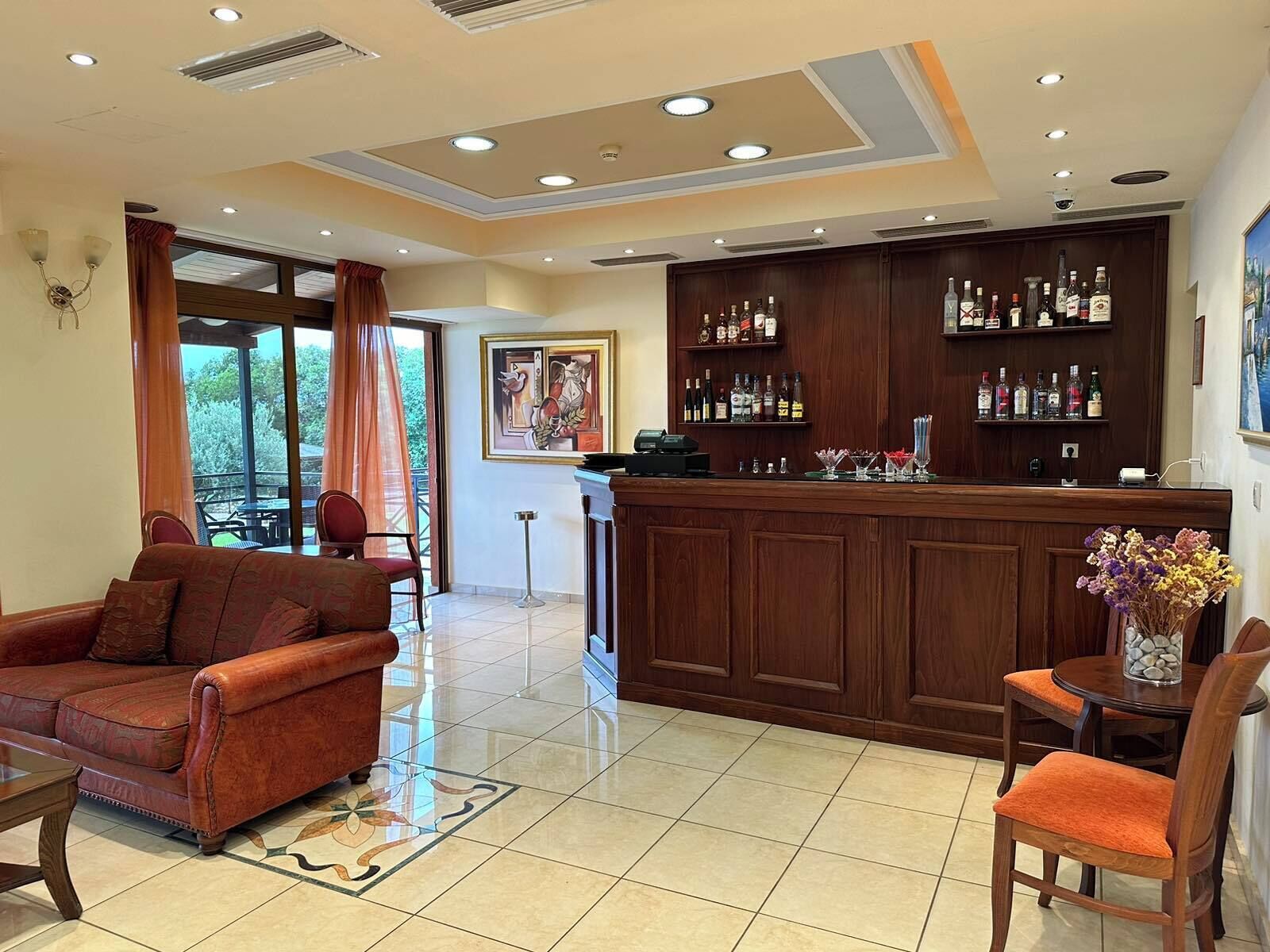 A hotel lobby with a bar area, seating, and a view of the outdoors.