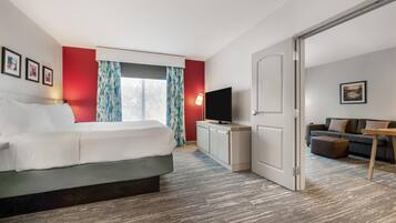 Une chambre d’hôtel avec un lit, une télévision, un bureau et un canapé.