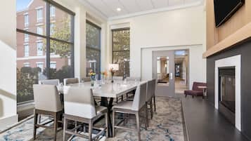 A modern dining area with a large table, chairs, and a fireplace.