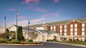 A Hilton Garden Inn with a brick facade, large windows, and a well-maintained lawn.