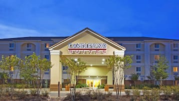 A hotel entrance with a sign reading 'CANDLEWOOD SUITES.'