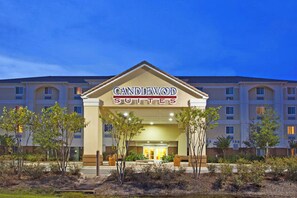 Entrada de un hotel con un letrero que dice 'CANDLEWOOD SUITES'.