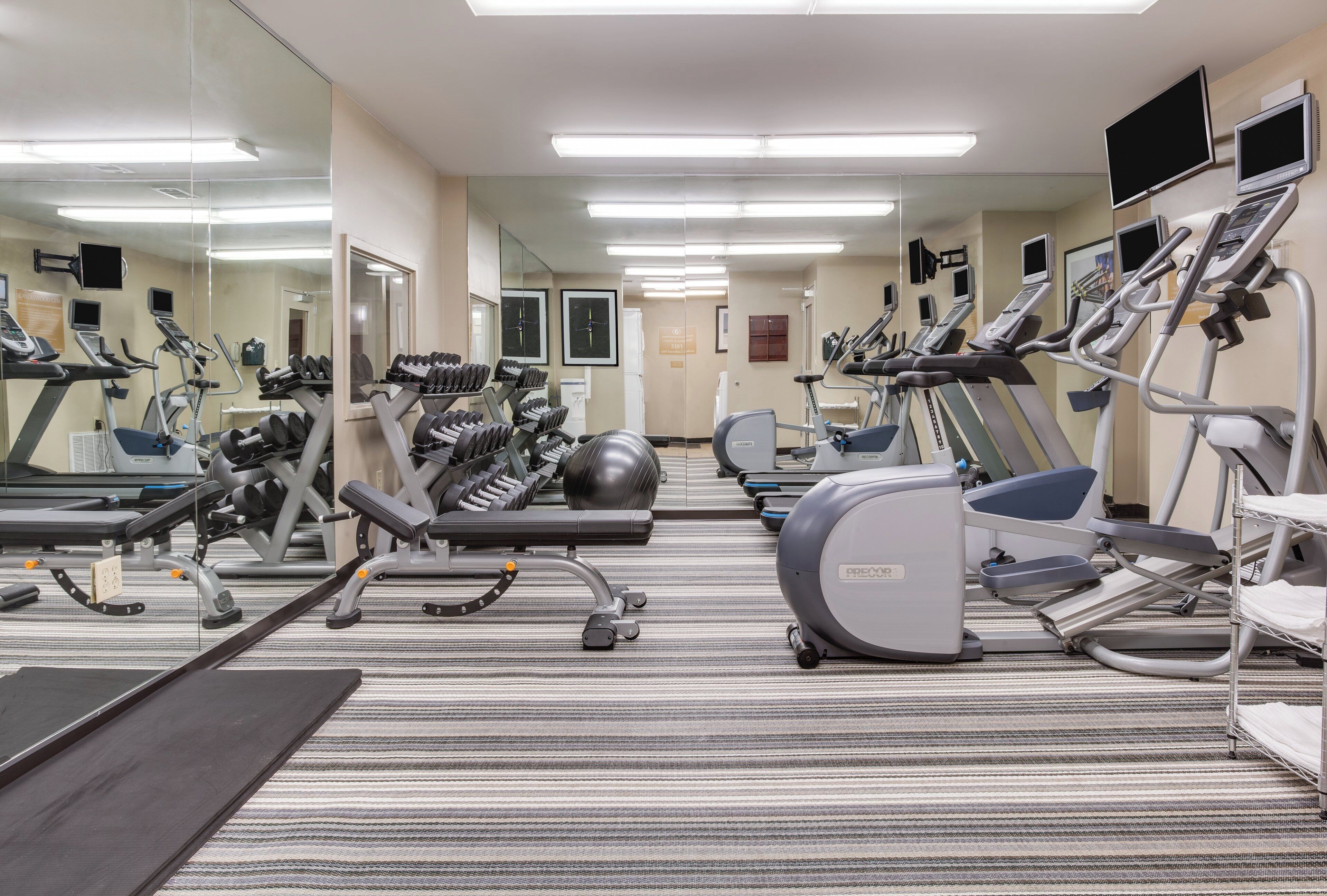 A gym with various exercise equipment, including treadmills, ellipticals, and weight machines.