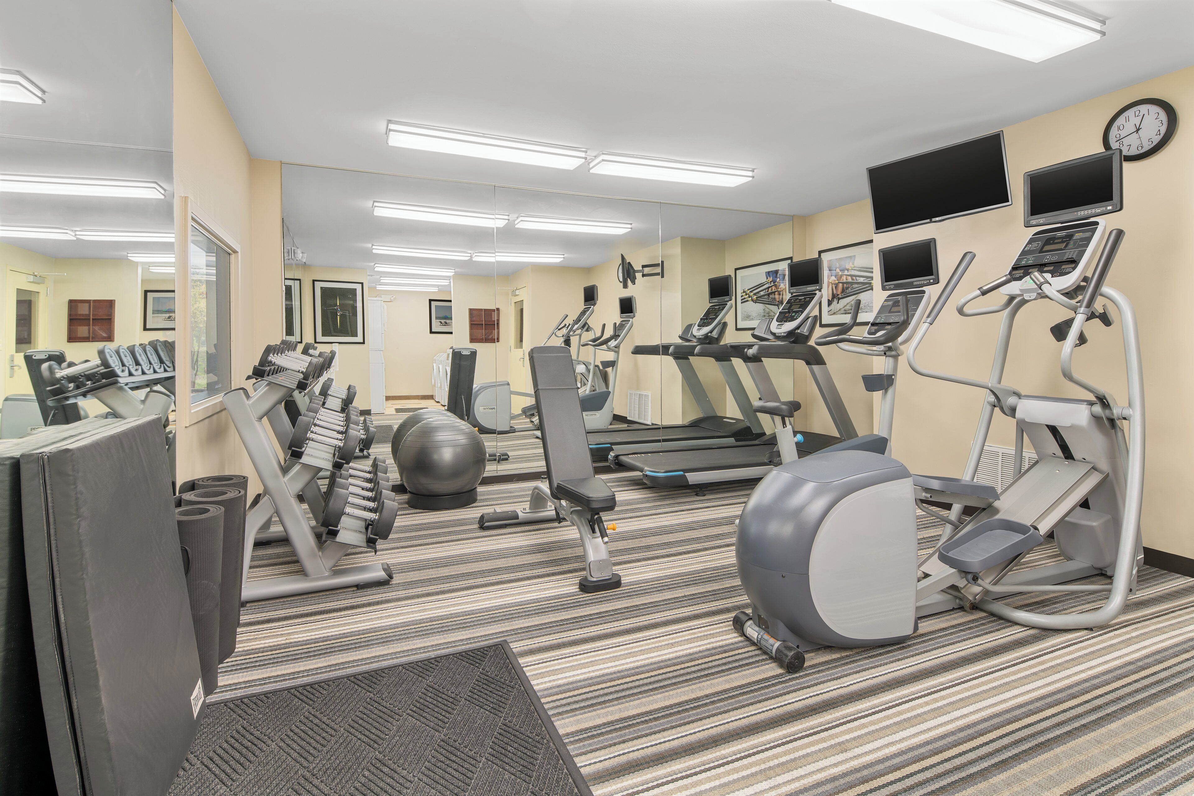 A gym with treadmills, elliptical machines, and free weights.