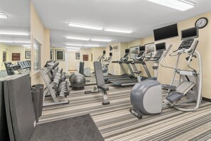 A gym with treadmills, elliptical machines, and free weights.