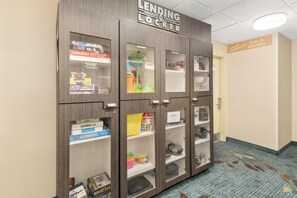A lending locker with various board games and items inside. - Candlewood Suites Destin-Sandestin by IHG (Miramar Beach)