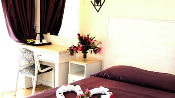 A hotel room with a bed, a desk, and a chair.