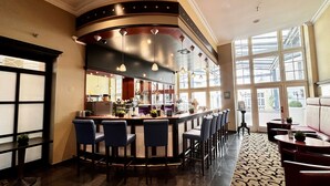 A bar area with a curved counter, multiple seating options, and large windows providing natural light. - Wyndham Garden Berlin Mitte (Berlin)