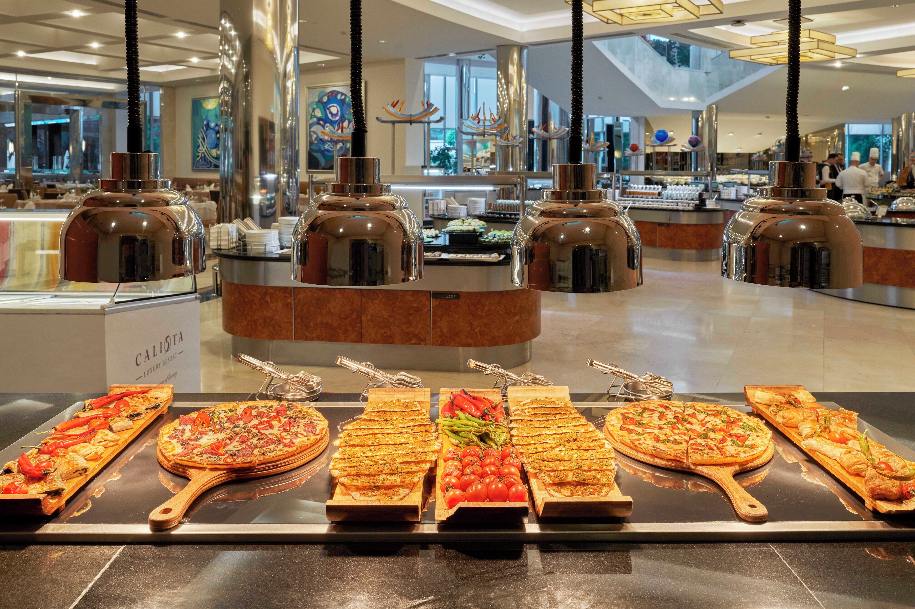 A buffet area with various pizzas and a sign that reads "CALISTA."