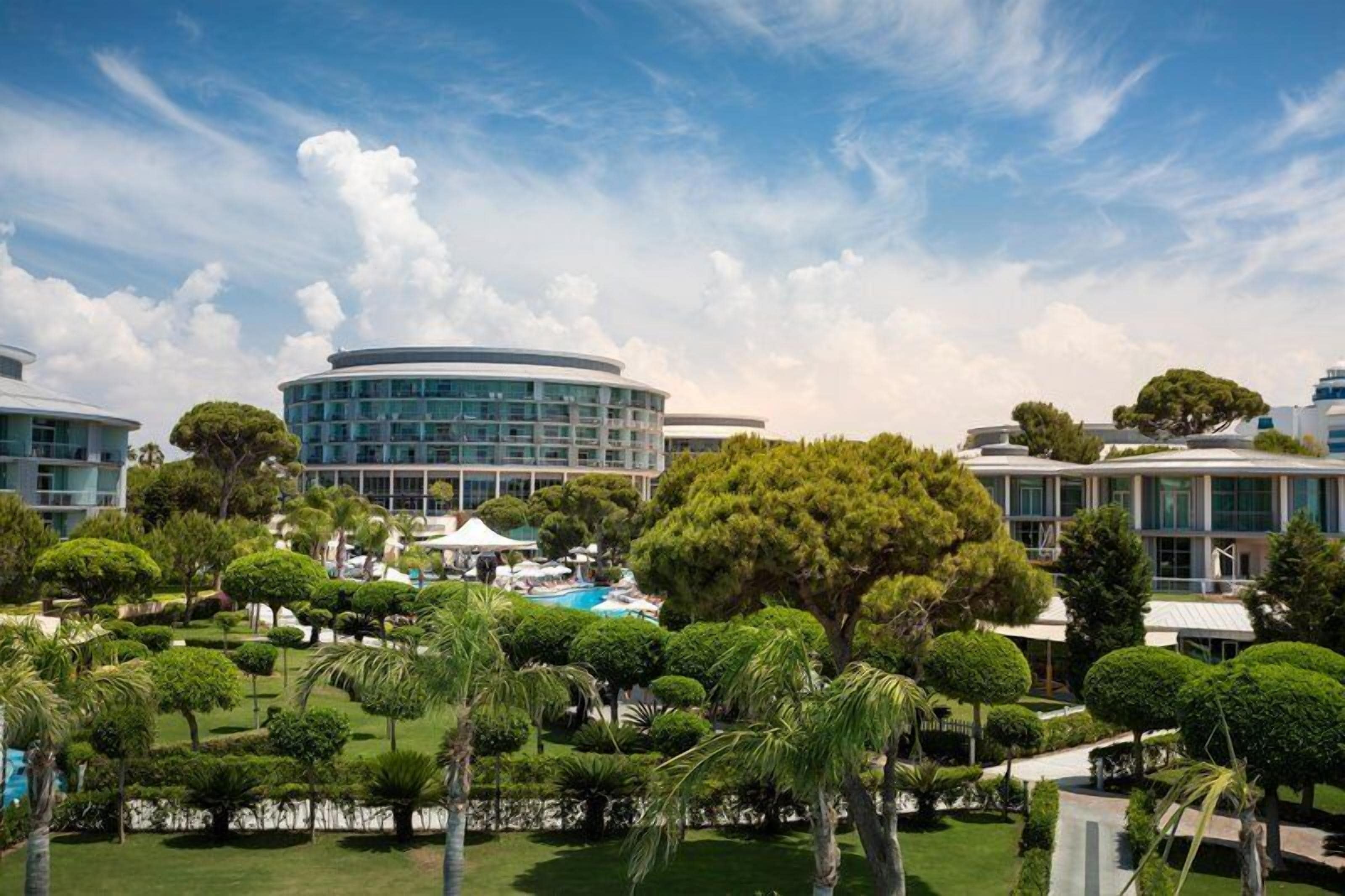 Un hotel con piscina, jardines cuidados y arquitectura moderna.