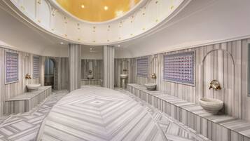 A spacious, elegantly designed bathroom with a large central sink, multiple smaller sinks, and a decorative ceiling.