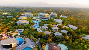 A resort with multiple circular buildings, a swimming pool, and a large circular water feature. - Calista Luxury Resort - All Inclusive (Serik)