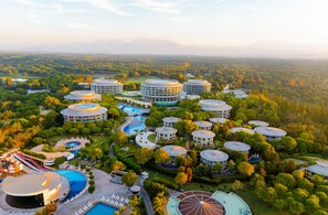 A resort with multiple circular buildings, a swimming pool, and a large circular water feature.